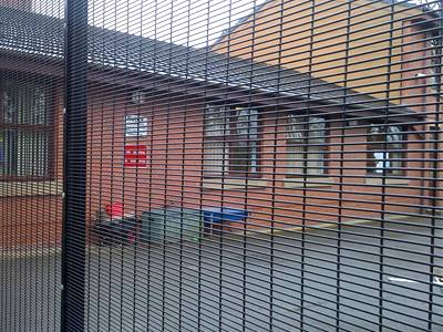 Black PVC coated 358 anti-climb fencing panels jointed together with posts to protect a single-storey red brick house.