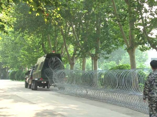 A trailer is deploying razor wires.