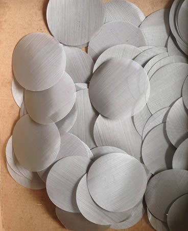 Many single layer extruder screen discs spread in the paper carton.