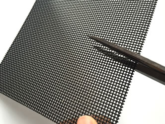 A scissor is cutting a piece of crime safe mesh.