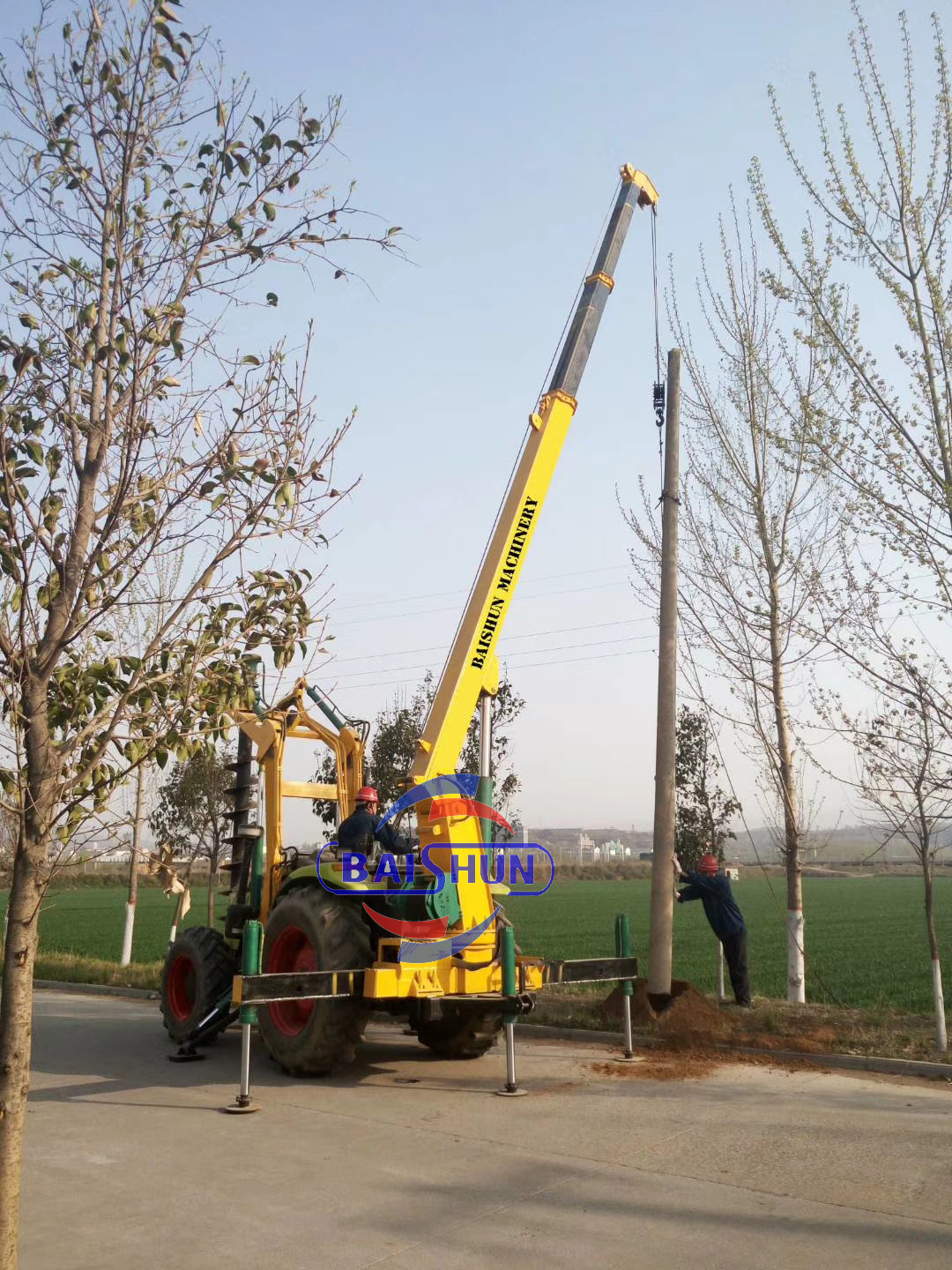 Wooden pole erecting by tractor mounted post hole digger machine